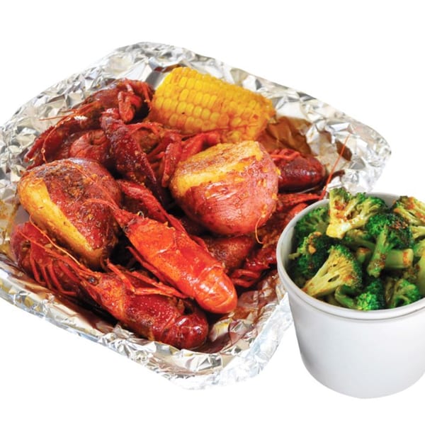 Louisiana Shack's Cajun crawfish boil with corn, potatoes, and a side of broccoli.