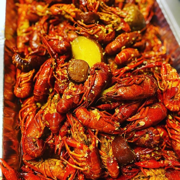Close-up of a large serving of Louisiana Shack's Cajun crawfish boil with potatoes and sausage.